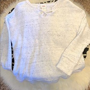white sweater with small crossing straps in front